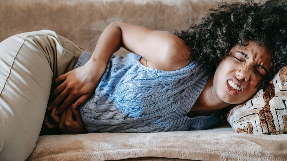 woman experiencing intense stomach pain because of IBD