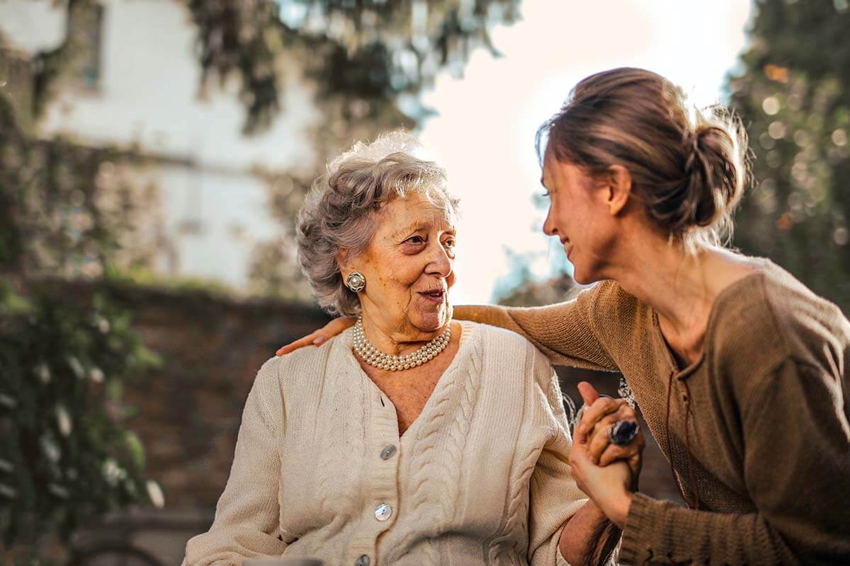 Elderly woman smiling with younger woman