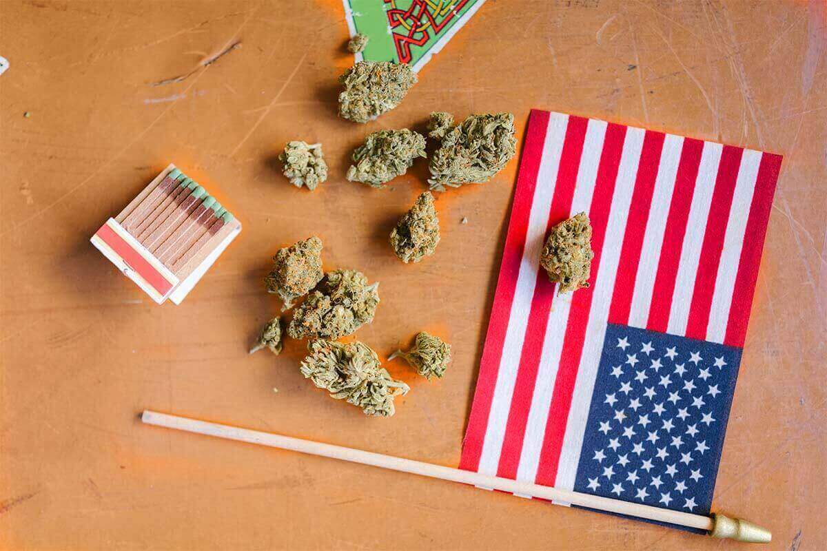 dried marijuana and an American flag on a wooden table