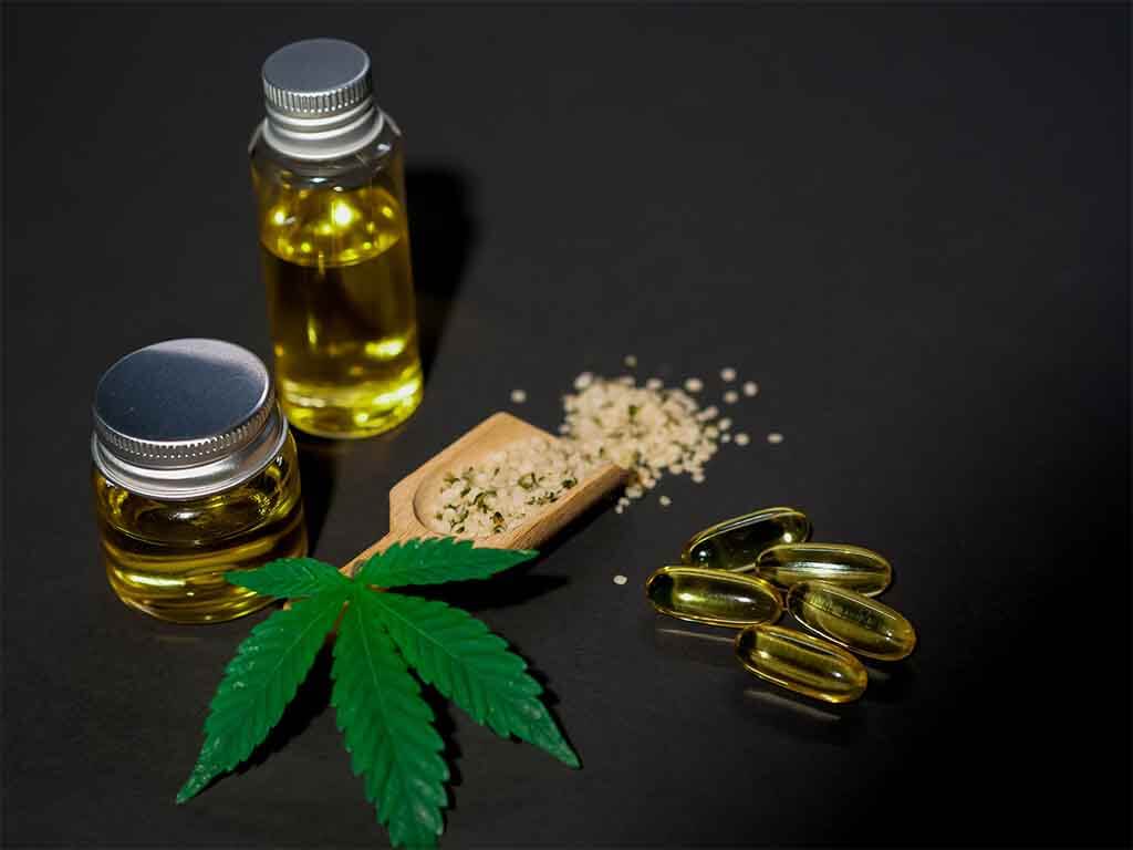 Marijuana leaf and CBD extract in pills and bottles