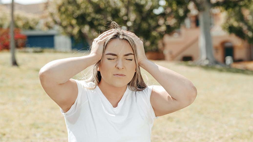Woman holding her head because of a migraine