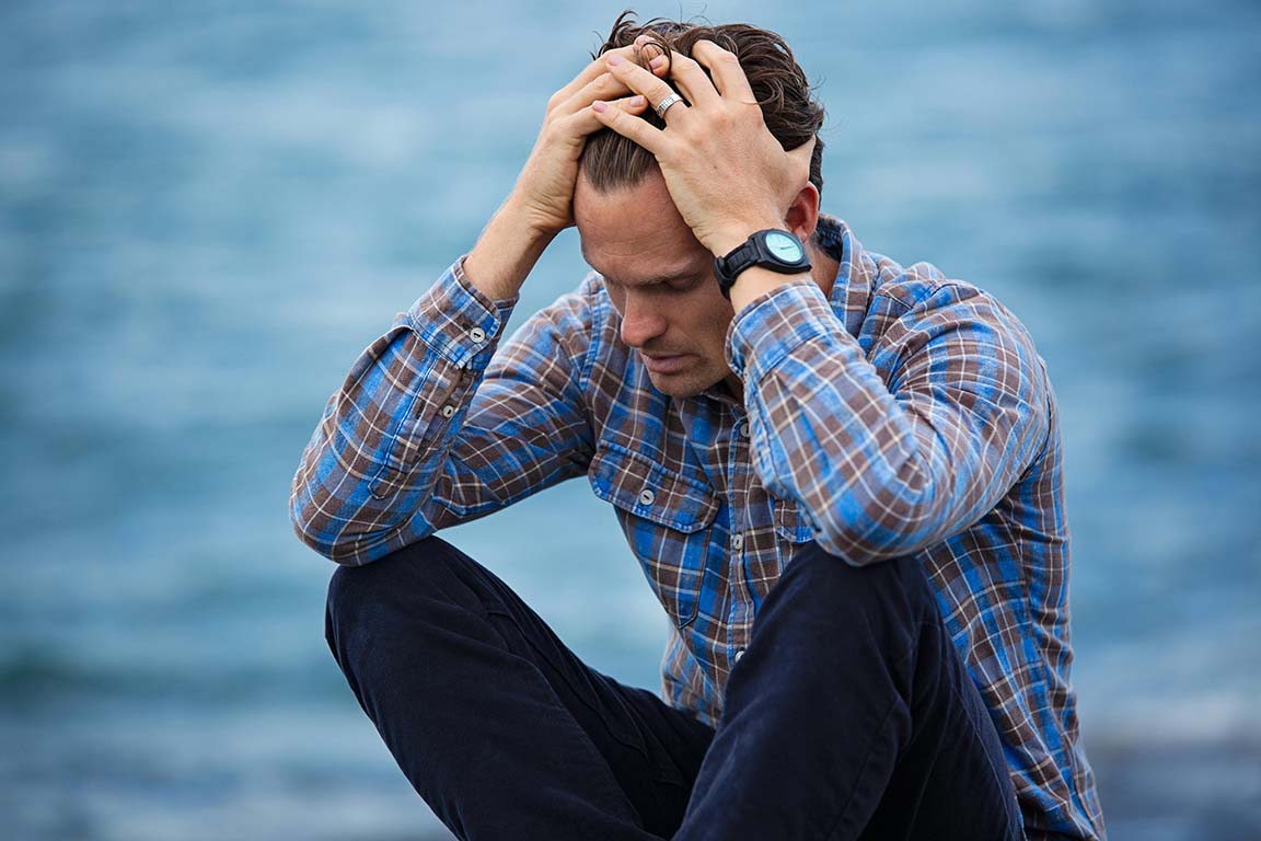 Man holding his head because of a migraine