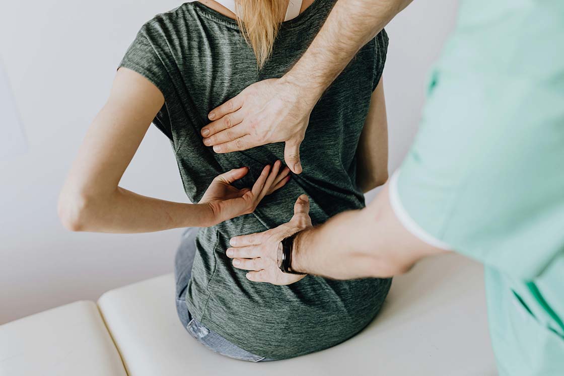 Woman with lower back pain being examined