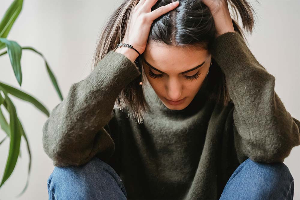 Girl with hands on her head after experiencing anxiety from THC